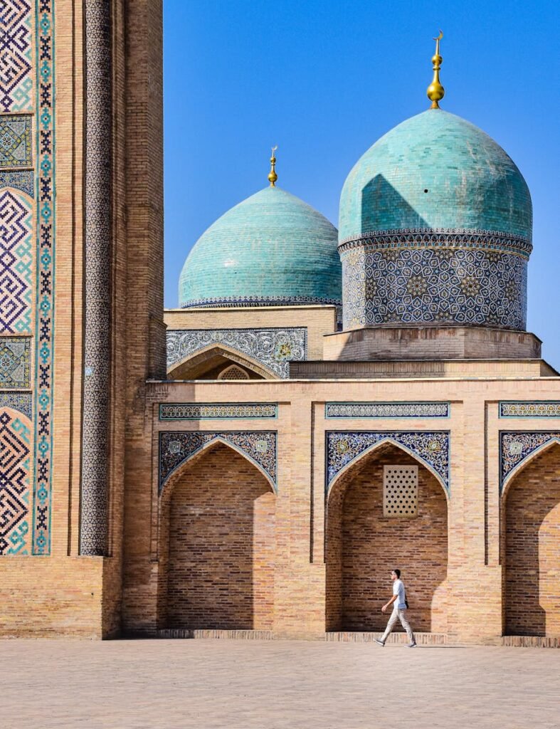 A traveler walking by the stunning architecture of a mosque in Tashkent, Uzbekistan.