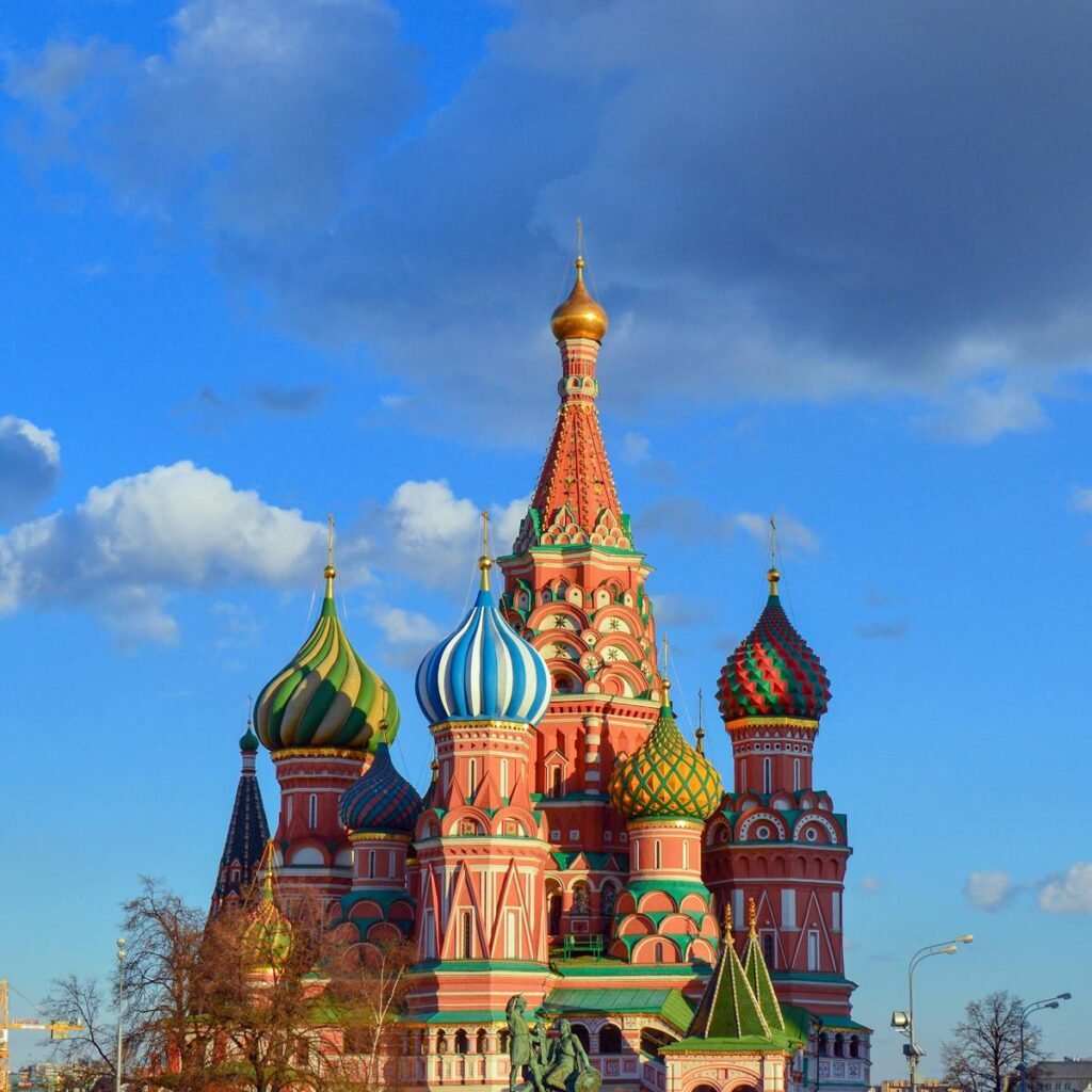 Colorful domes of St. Basil's Cathedral against a vibrant blue sky in Moscow, Russia.