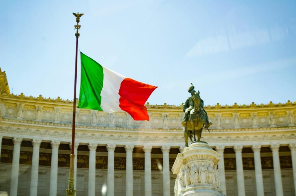 Italian flag waving in front of the Vittoriano monument in Rome, a symbol of Italy's rich history.